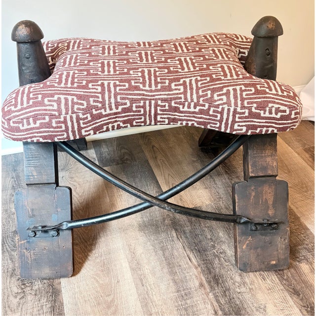 A distinctive pair of vintage camel saddle stools with generously proportioned upholstered seats and handcrafted wood and...