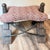 A distinctive pair of vintage camel saddle stools with generously proportioned upholstered seats and handcrafted wood and...