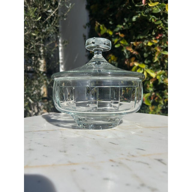 Vintage clear cut glass jar featuring a faceted body, pedestal base, and matching domed lid with solid glass knob. The...