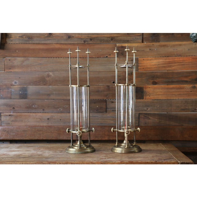 Striking vintage pair of Chapman Manufacturing Company brass and glass hurricane candle holders, dated 1985. These...
