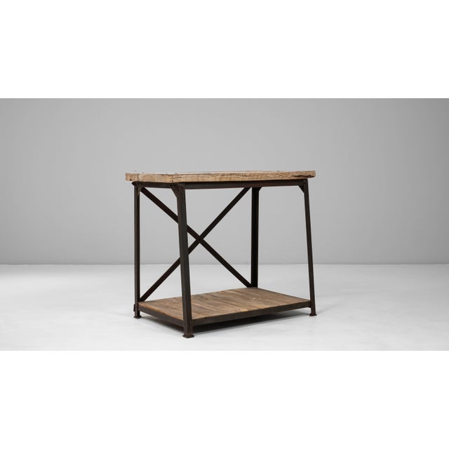 This 20th Century French industrial wooden table on a metal base combines utilitarian structure with warm, timeworn...