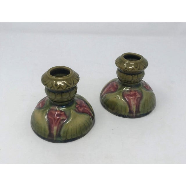 After Brush McCoy Majolica Amaryllis candlesticks, circa 1920's- 1930's, very nice coloration of purple-rose flowers with...