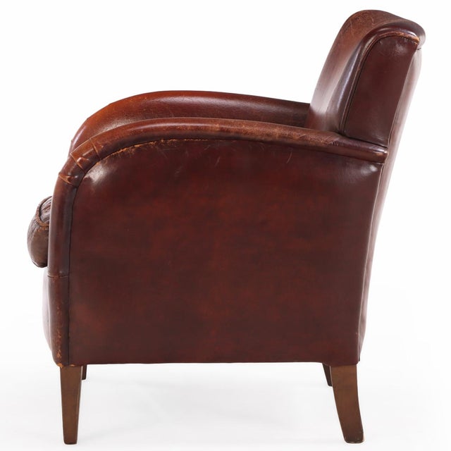 A classic leather club chair featuring warm, aged leather upholstery. The generous proportions, straight back, gently...