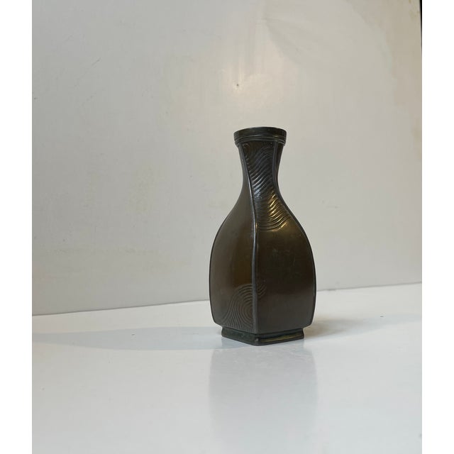 A rare bottle-shaped metal vase with unusual ornamental relief panels. Designed and made by just andersen in denmark circa...