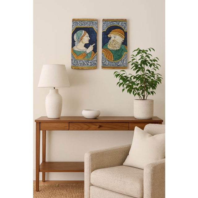 A striking pair of hand-painted Italian terracotta tiles, richly decorated in the maiolica (majolica) tradition. Each...