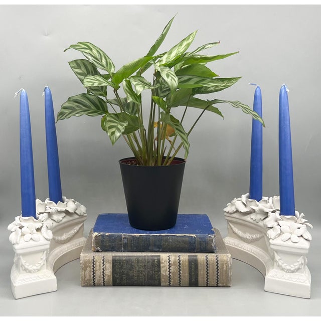 Elegant pair of Italian porcelain candle holders featuring sculptural rose blooms and layered florals cascading across a...
