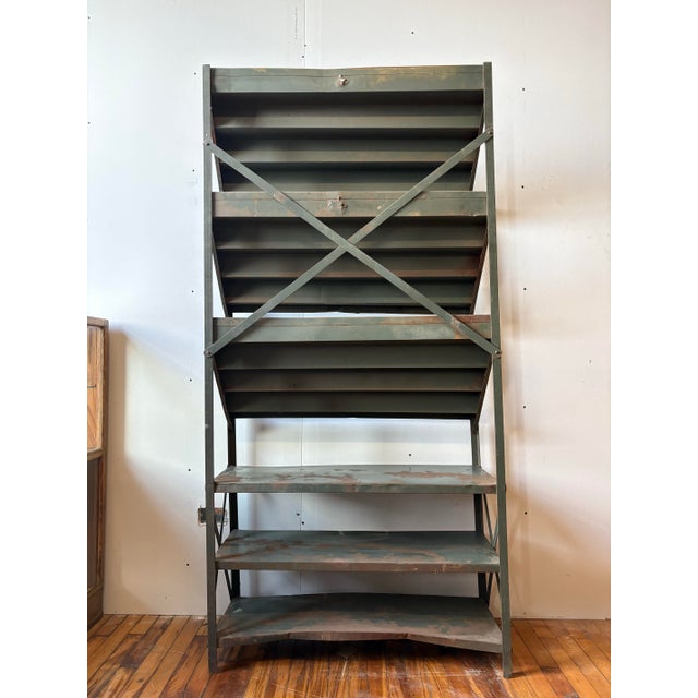 Vintage store display rack. Has a gritty weathered green paint finish and lived-in patina. Has many shallow tiers, each...