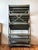 Vintage store display rack. Has a gritty weathered green paint finish and lived-in patina. Has many shallow tiers, each...