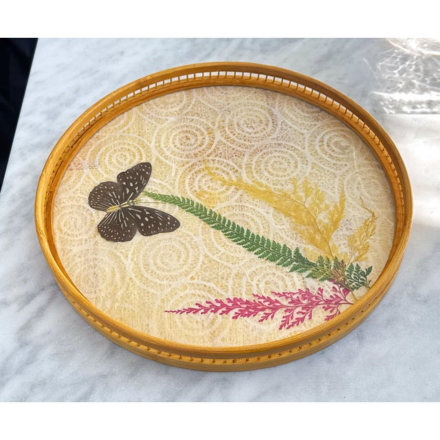 Very pretty and in excellent condition, vintage woven rattan tray featuring a butterfly against a backdrop that has a...