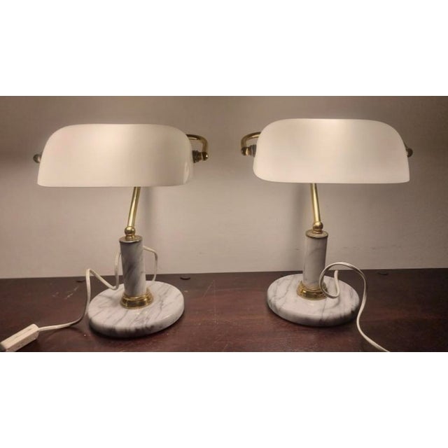 Two identical lamps. White marble and brass bases. Excellent condition. White glass shades. Also in very good condition (a...