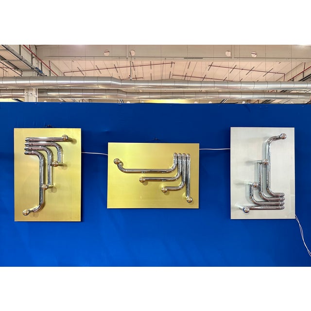 3 wall sconces attributable to Giacomo Benevelli from the 70s, gold and silver steel panels, chromed steel tubes, equipped...