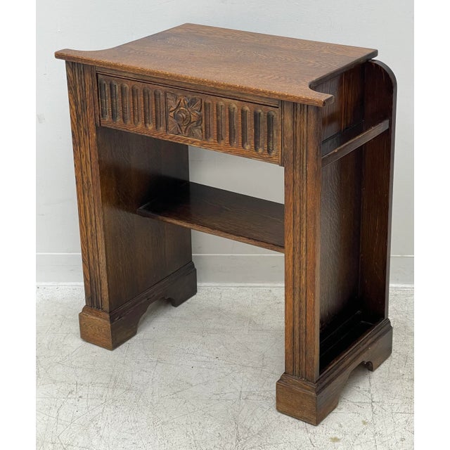 This Arts and Crafts side table features distinctive hand-carved detailing. The drawer front displays a floral motif...