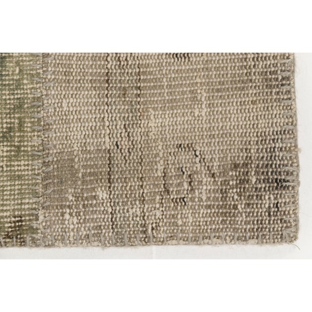 This is a vintage Turkish Oushak rug from the Mid 20th Century. The piece was hand-knotted.