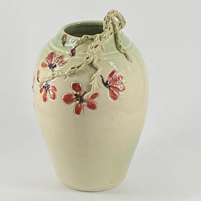 This beautiful vase has a glaze finish and is decorated with cherry blossoms and an applied relief branch the colors are...