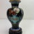 Fabulous little cloisonné vase. The black background is dramatic with a turquoise vase that has a piece of coral and a...