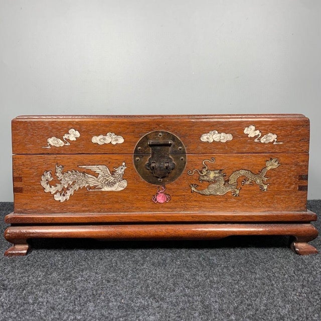 A beautiful rectangular Chinese hardwood storage chest, expertly decorated with **mother-of-pearl shell inlay** featuring...