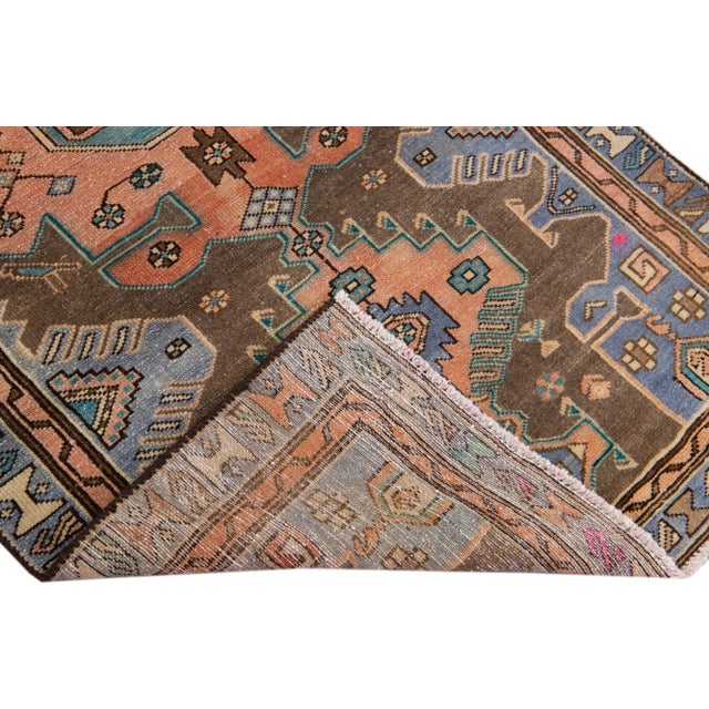 Beautiful vintage Persian distressed hand-knotted wool rug with an ivory color field. This piece has navy blue and brown...