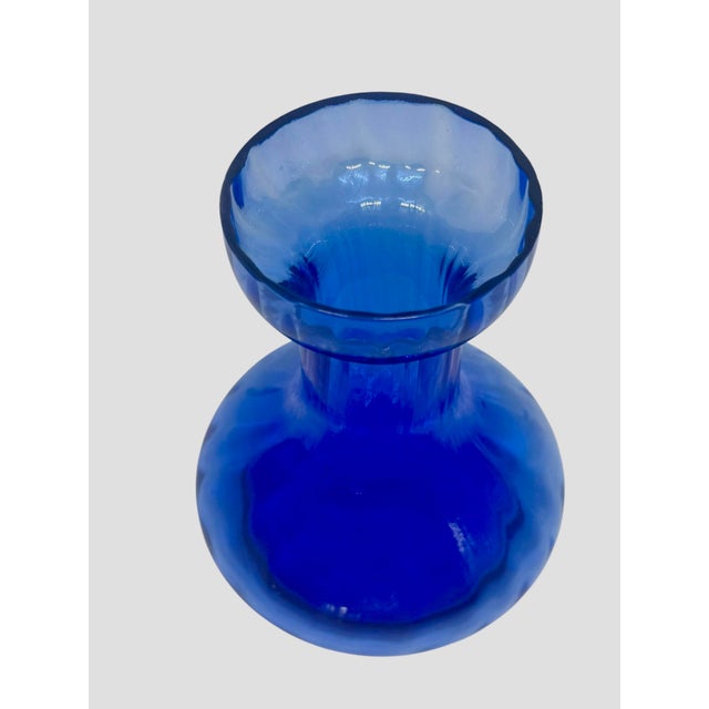 The is a vintage cobalt blue glass hyacinth forcing vase. This specific hourglass-like shape-featuring a wide bulbous...