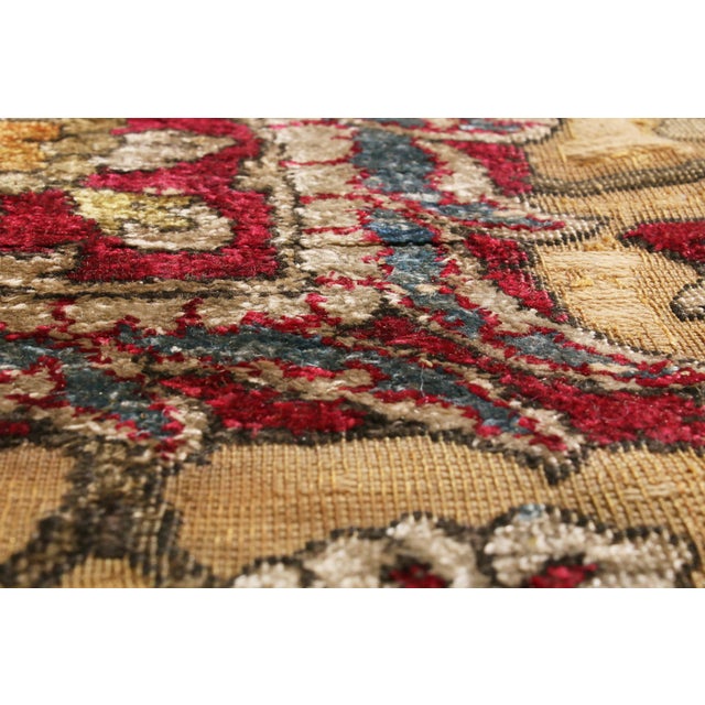 Hand knotted in an exceptionally luminous silk from Persia in 1910, this antique Kashan piece marries finesse and elegance...