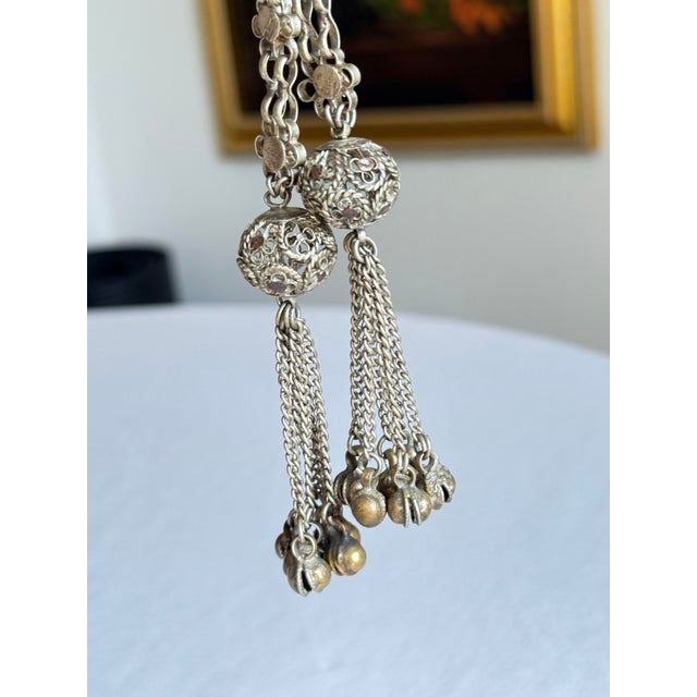 Vintage 1970s bohemian style dangling drop earrings with mixed silver and brass tone metal, intricate filigree, and...