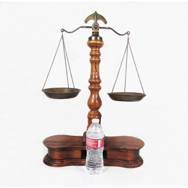 Classic brass-and-wood balance scale with a beautifully turned column and two hanging pans—an iconic “cabinet of...