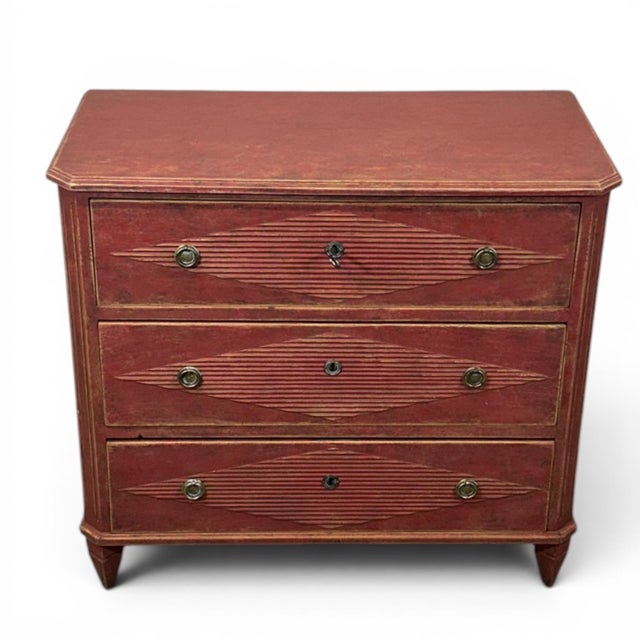 A classic Gustavian-style chest of drawers in a muted red with a beautiful patina. All three drawers feature a decorative...