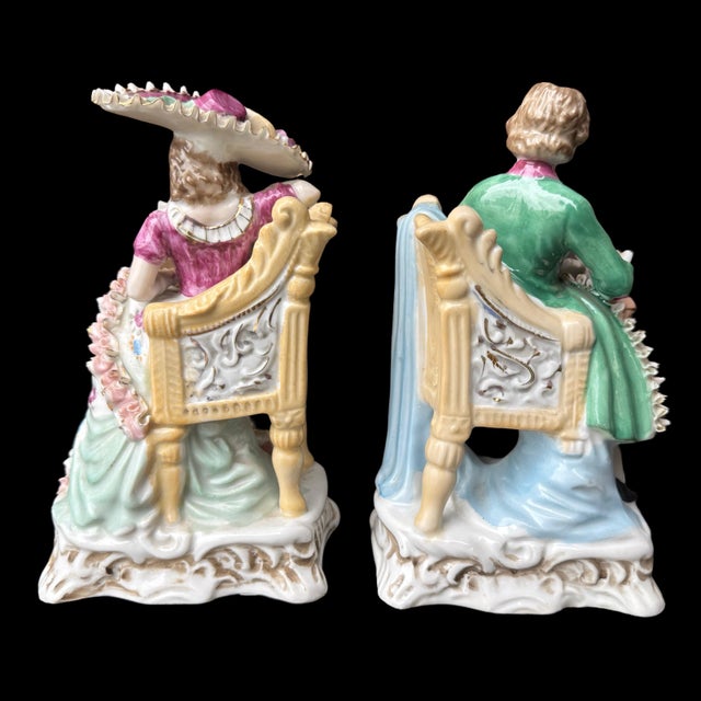 This exquisite pair of vintage German porcelain figurines captures a romantic moment between a young couple seated in...