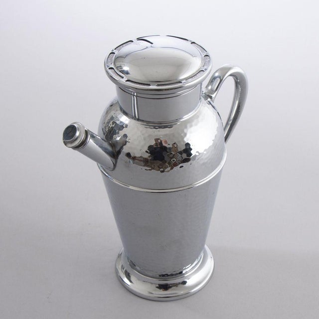 H: 23.5cm W: 19cm D: 11.5cm An American art deco hammered chrome cocktail shaker with a recipe dial lid, design registered.