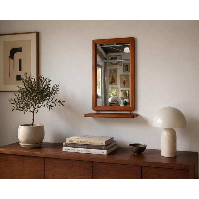 Beautiful Mid-Century Danish Modern wall mirror by Fakse, Denmark, featuring a warm teak wood frame with softly rounded...