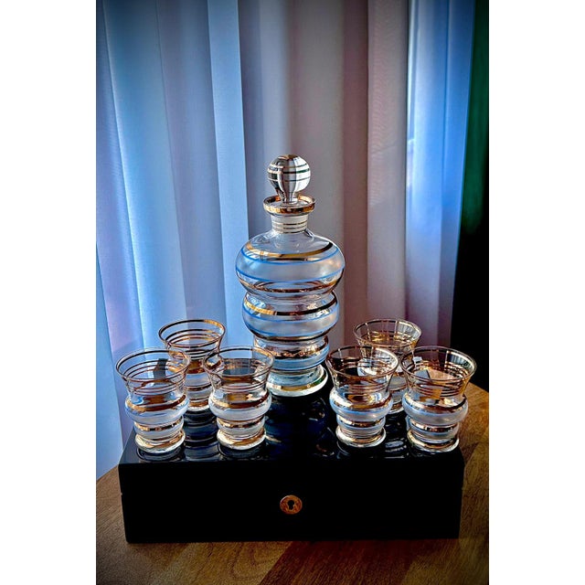 Decorative mid-century decanter set comprising one rounded decanter with stopper and six matching glasses. Frosted bands...