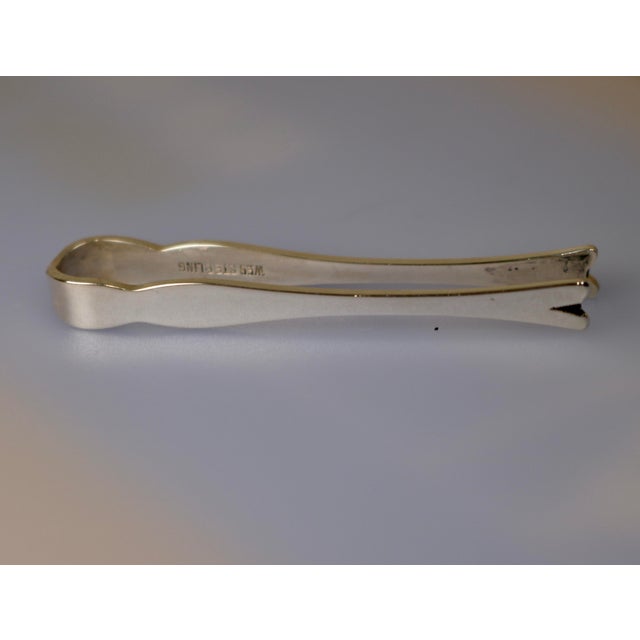 A dainty and mid-century simple pair of sugar cube tongs. These were made for saccharin tablets which are still made...