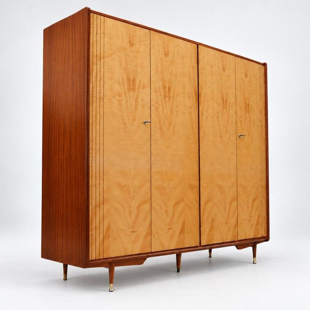 Vintage 4-door wardrobe / linen cabinet from the 1960s or 70s. This spacious vintage wardrobe combines a light wood grain...
