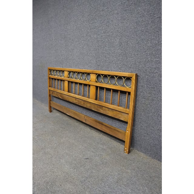 Mid-century Baker Furniture headboard featuring a warm walnut-toned finish, geometric brass ring detailing, and vertical...