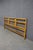 Mid-century Baker Furniture headboard featuring a warm walnut-toned finish, geometric brass ring detailing, and vertical...