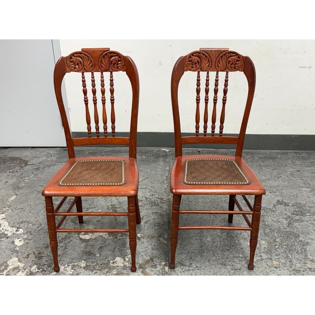 Design Plus Gallery presents a pair of Victorian Oak Side Chairs. They have carved crest rails, arched backs, turned...