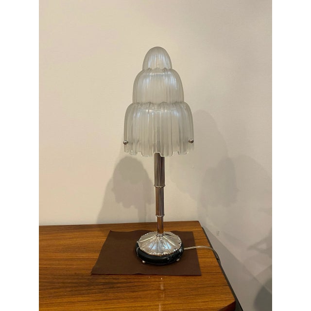 Magnificent pair of French Art Deco table lamps created by Marius Ernest Sabino, (1878-1961). The shades are clear frosted...