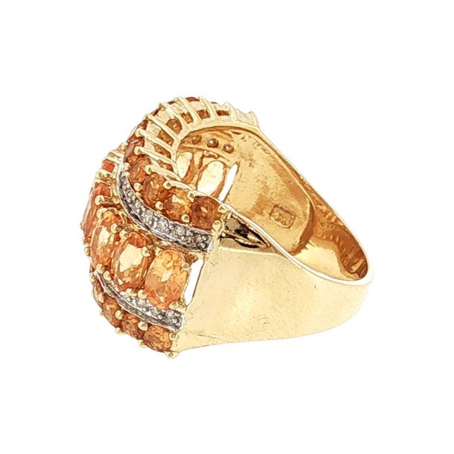 A late 20th-century fashion ring crafted in 14k gold. The band features oval-cut orange garnets, exuding a vibrant orange...