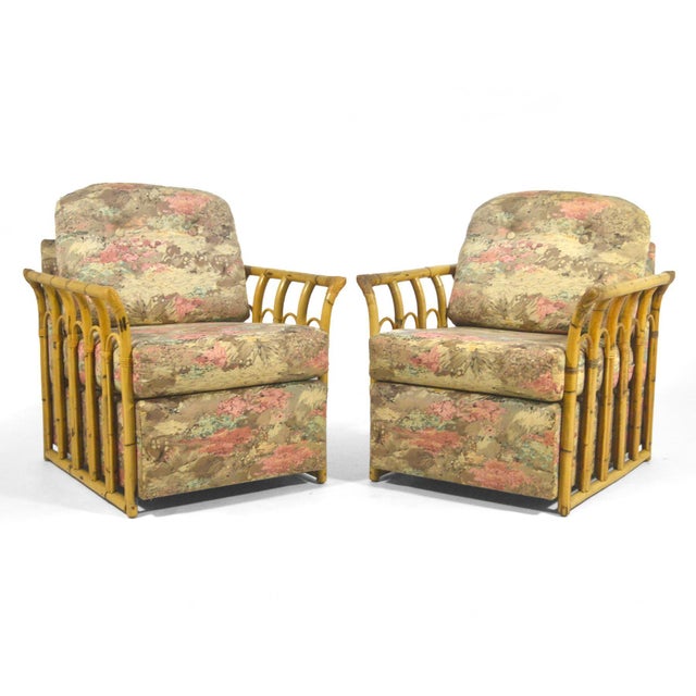 This pair of tropical club chairs from the late 40s/early 50s have external arms which frame the upholstered bodies in...