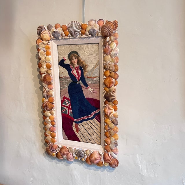 A lively maritime woolwork panel, likely dating to the late 19th or early 20th century, showing a graceful young woman in...