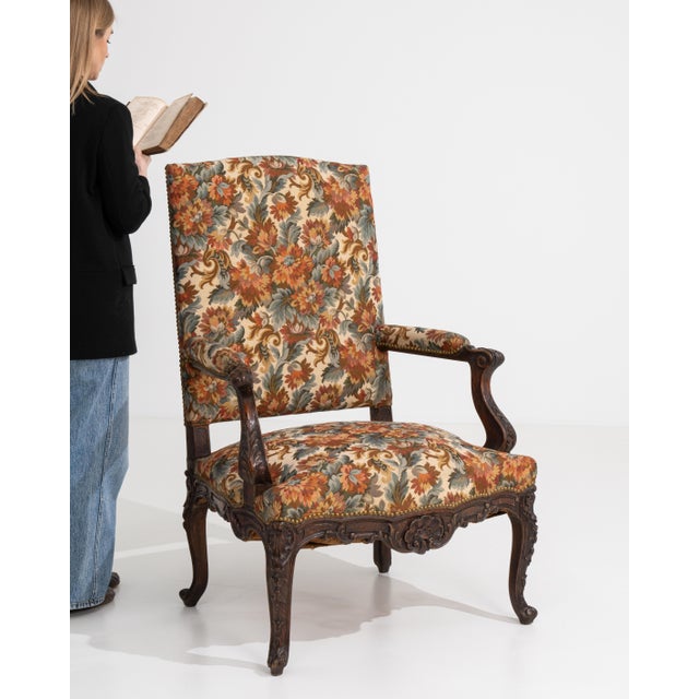 A classic Louis XV armchair featuring elegant cabriole legs and curved lines, softened by detailed needlepoint upholstery....