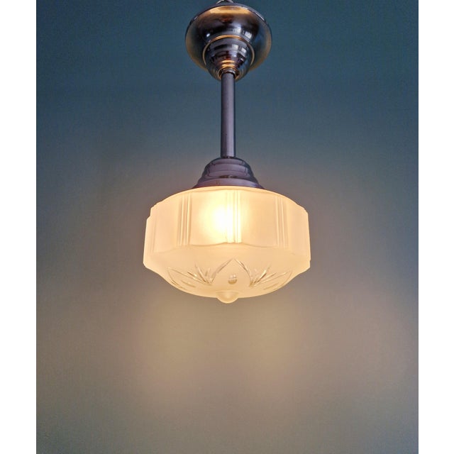 Art Deco frosted glass pendant light with a chrome-plated metal frame, 1920s-30s. The pendant light has been rewired and...