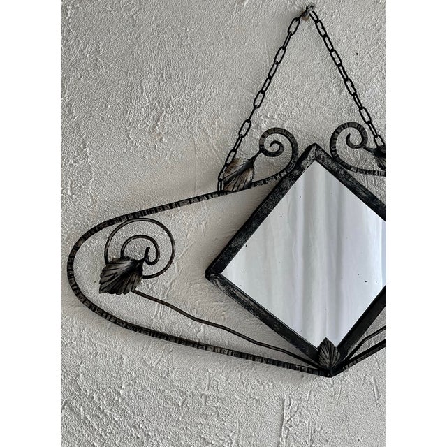 A 1930s mirror, combining the refinement of Art Nouveau and the elegance of Art Deco. The wrought iron frame, with its...