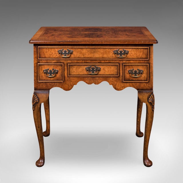 This is a vintage Georgian revival lowboy. An English, burr walnut four drawer side or hallway table, dating to the late...