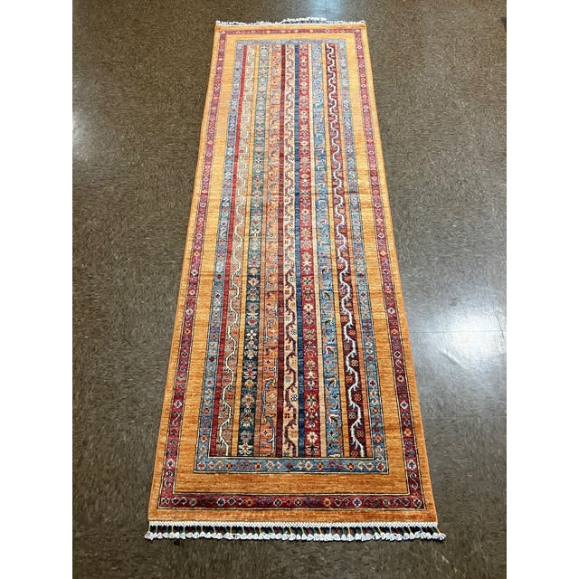 Vintage Hand-knotted Afghan runner with a striped field featuring geometric motifs in gold, sky blue, ivory, rust, and...