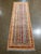 Vintage Hand-knotted Afghan runner with a striped field featuring geometric motifs in gold, sky blue, ivory, rust, and...