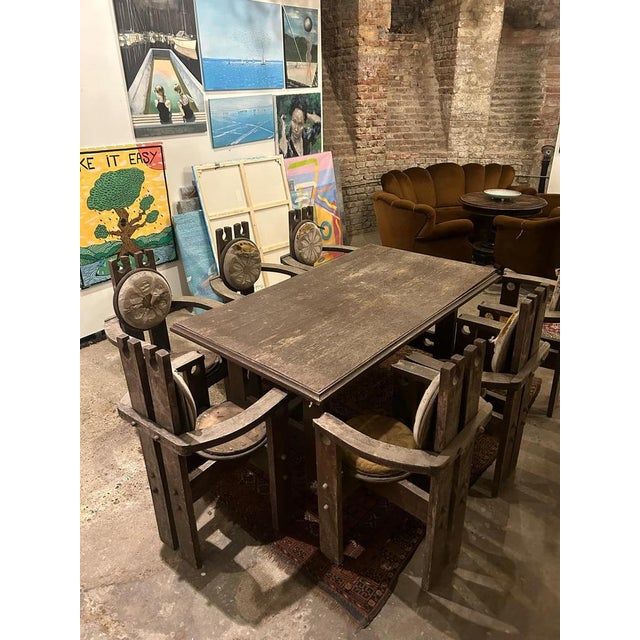 This dining set, crafted from solid oak, consists of 8 chairs and a matching table, exuding a distinctive rustic charm. A...