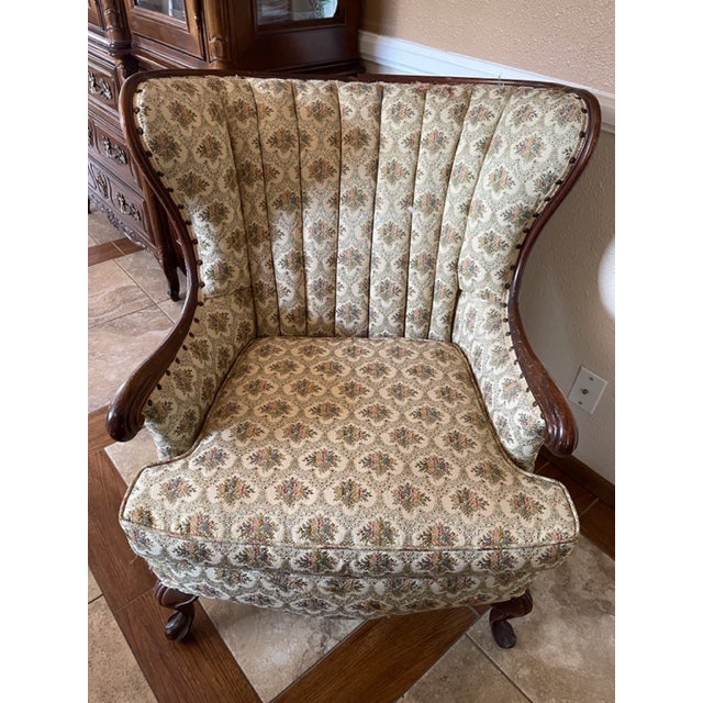 This lovely Vintage Mid-Century set has two wingback chairs with an ottoman. The upholstery has an Ivory floral brocade...