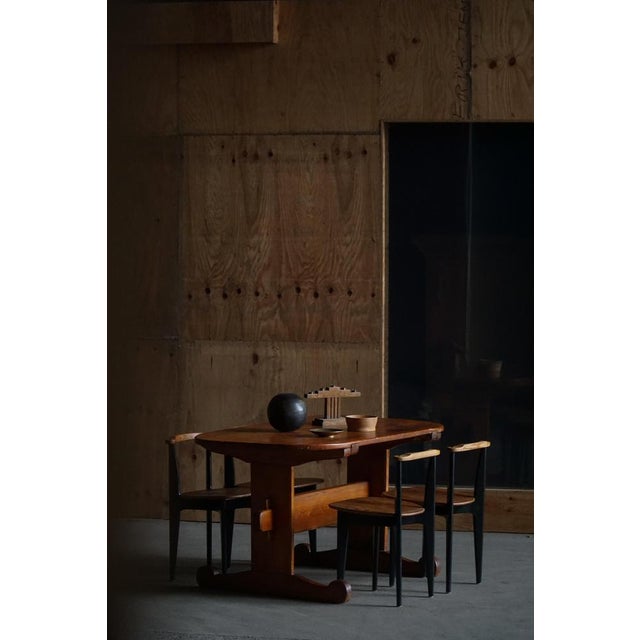 A traditional Swedish oval trestle table, crafted from solid pine, exemplifying the simplicity, functionality, and rustic...