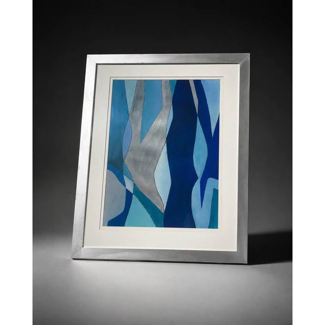 Modern abstract artwork featuring layered organic shapes in shades of blue, navy, turquoise, gray, and metallic silver....