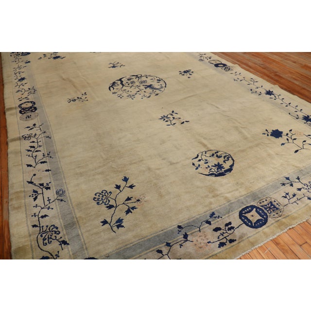 An early-20th-century room size Chinese rug in the navy, beige, and gray color family. The wool and feel of the rug is...